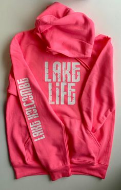 "\"Our SUPER popular Lake Life hoodie is now available in NEON colors!! (Color in main listing photo is Neon Pink.) \"Lake Life\" adult hoodie, customized with the lake name of your choice! These are navy in color with a distressed white font design on the front and down the arm. Extremely soft, like wearing a cozy blanket! Unisex, but fit true to size. ENTER THE ARM CUSTOMIZATION IN THE \"NOTE TO SELLER\" BOX DURING CHECKOUT (I've had lots of questions about this) and please feel free to send a Lake Vacation Shirt Ideas, Lake Wear, Lake Sayings For Shirts, Lake Life Sweatshirt, Ski School