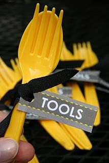 a person holding a yellow plastic fork with tools on it's handle and tag