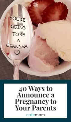 a spoon with some ice cream and strawberries in it on top of a plate