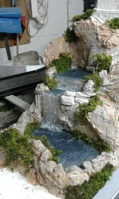 a model waterfall with moss growing on the rocks and water running down it's sides