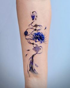 a woman's leg with blue flowers and feathers on the side of her body