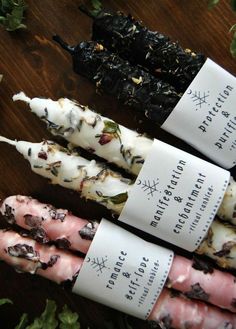 four different types of candy sticks sitting on top of a wooden table next to plants