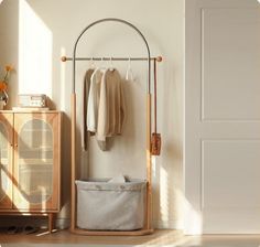 an ironing board with clothes hanging on it next to a wooden cabinet and door