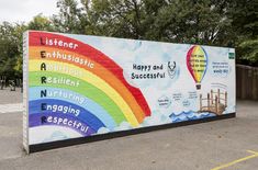 a large mural on the side of a building with rainbows and hot air balloons