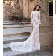 a woman in a wedding dress standing on some steps