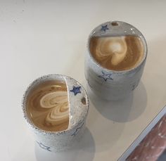 two cups with liquid in them sitting on a table