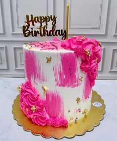 a birthday cake decorated with pink flowers and gold sparkles is on a platter