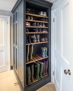 an open shoe cabinet with several pairs of boots on the bottom shelf and one pair of rubber boots on the top shelf