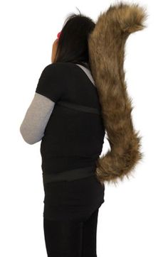 a woman is holding a large furry animal tail on her back while she's looking at the camera