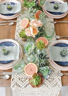 the table is set with succulents and plates