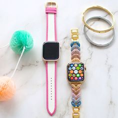 an apple watch and other accessories on a marble table with yarn, pom - pom balls