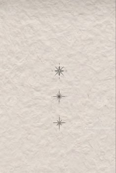 three snowflakes are shown in the middle of a white paper background with black ink