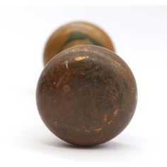 two old wooden knobs on a white surface with no one in the photo looking at them