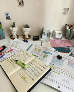 an open notebook sitting on top of a desk next to other office supplies and papers