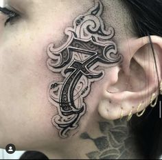 a woman with a tattoo on her neck and behind the ear has a cross in it