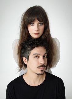 a man with long hair sitting on top of a woman's head