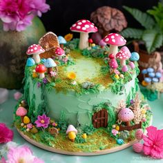 a green cake decorated with mushrooms and flowers