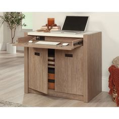 a laptop computer sitting on top of a wooden desk