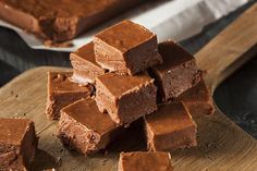 pieces of chocolate fudge cake sitting on top of a wooden cutting board