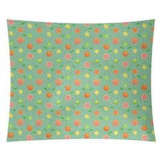 a green pillow with orange and pink flowers on the front, against a white background