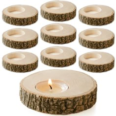 a set of eight tea light holders made out of tree slices with a lit candle in the middle