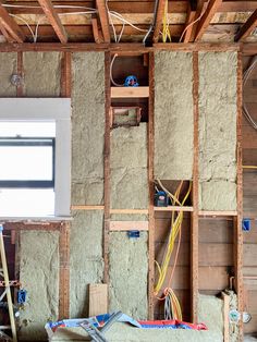 a room that is being remodeled with wood framing and electrical wires on the wall above it