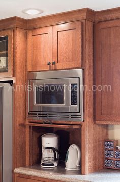 a kitchen with wooden cabinets and stainless steel appliances, including a coffee maker on the counter