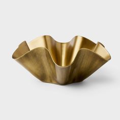 a large brass bowl with wavy shapes on the bottom and sides, sitting in front of a white background