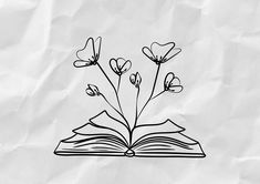 an open book with flowers on top of it