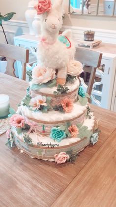 a three tiered cake decorated with flowers and a lamb figurine on top