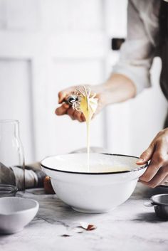 a person is pouring something into a bowl