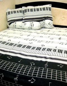 a bed with musical notes on the sheets and pillows, along with a pillow case