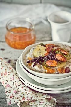 a bowl of oatmeal with fruit and nuts in it on a table