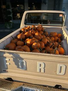 a pick up truck filled with pumpkins in the bed