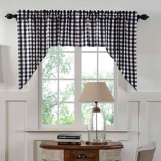 a living room with white walls and black checkered curtains