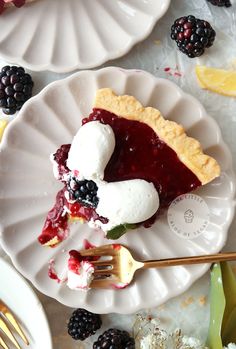 a slice of pie on a plate with berries and ice cream next to it, ready to be eaten