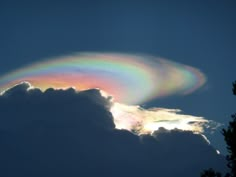 a rainbow in the sky above some clouds