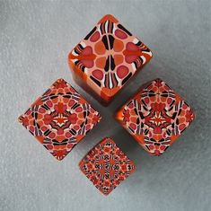 four orange and black square shaped objects on a gray surface, with one smaller object in the middle