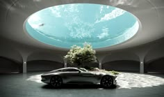 a futuristic car is parked in front of a round pool with trees and plants on it