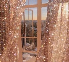 an open window with sparkling curtains in front of it