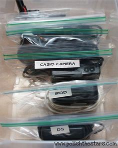 three plastic containers with various electronic devices in them and labels on the lids that read casio camera