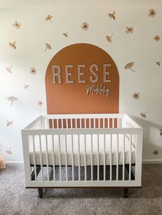 a baby's room with a crib and wall decals on the walls