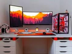 two computer monitors sitting on top of a desk