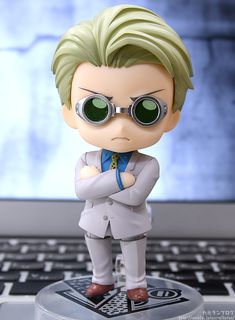 a figurine that is sitting on top of a computer keyboard, with his arms crossed