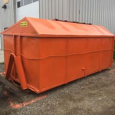 an orange container sitting in front of a building