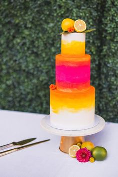 a multi - colored cake with lemons and limes sits on a white table