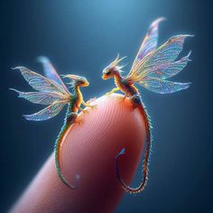 two tiny dragon figurines sitting on top of a finger