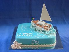 a birthday cake with a sailboat on top and the number 50 written in white