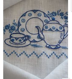 two teacups and a plate on a table cloth