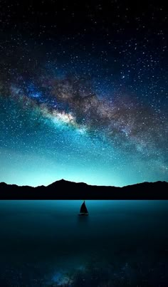 the night sky is filled with stars and milky over mountains, reflecting in calm water